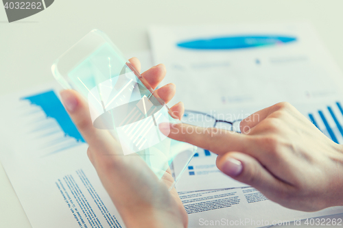 Image of close up of woman with transparent smartphone