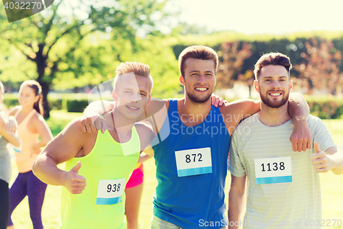 Image of happy friends with racing badge numbers