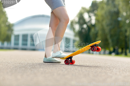 Image of close up of female feet riding short skateboard