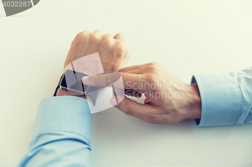 Image of close up of male hands setting smart watch