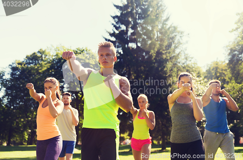 Image of group of friends or sportsmen exercising outdoors