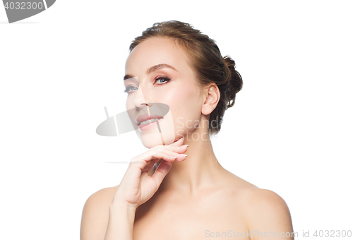 Image of beautiful young woman touching her face