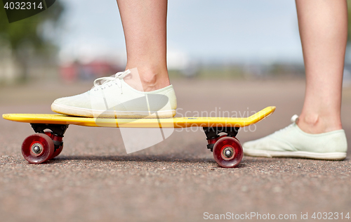 Image of close up of female feet riding short skateboard