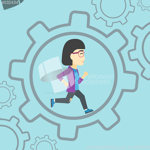 Image of Business woman running inside the gear.