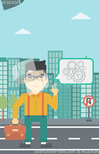 Image of Businessman pointing at cogwheels.