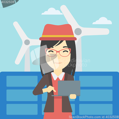 Image of Woman checking solar panels and wind turbines.