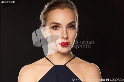 Image of beautiful woman in black over dark background