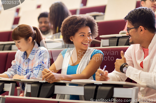 Image of group of students with notebooks in lecture hall