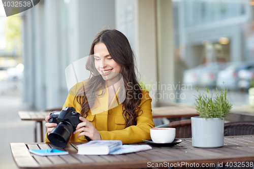 Image of happy tourist woman with camera at city cafe