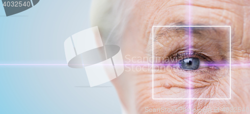 Image of close up of senior woman eye with laser light