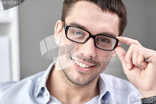 Image of portrait of businessman in eyeglasses at office