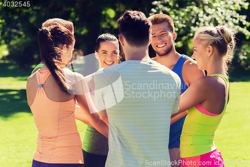 Image of group of happy friends with hands on top outdoors