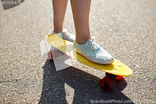 Image of close up of female feet riding short skateboard