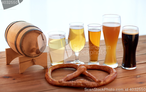 Image of close up of beer glasses, barrel and pretzel