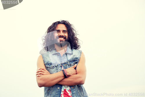 Image of smiling young hippie man in demin vest