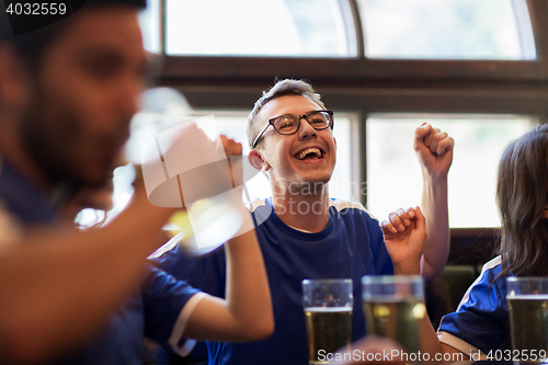 Image of football fans or friends with beer at sport bar