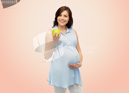 Image of happy pregnant woman holding green apple