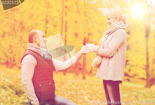 Image of smiling couple with engagement ring in gift box