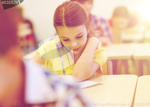 Image of group of school kids writing test in classroom