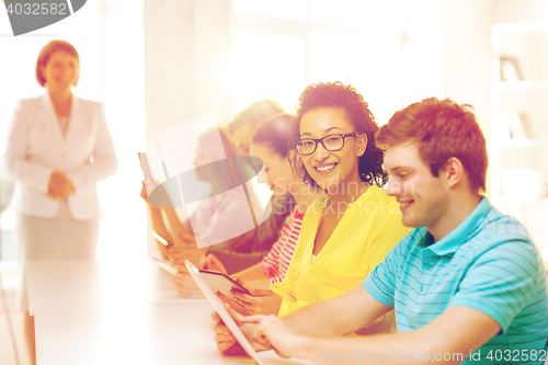 Image of smiling female students with tablet pc at school