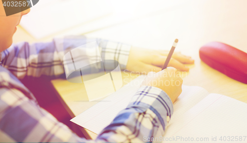 Image of close up of schoolboy writing test at school