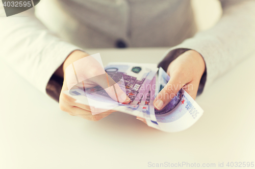 Image of close up of woman hands counting euro money