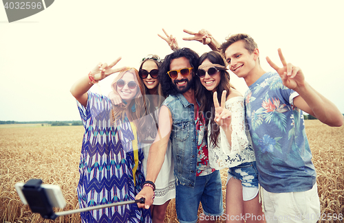 Image of hippie friends with smartphone on selfie stick