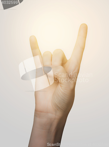 Image of close up of woman hand showing rock sign