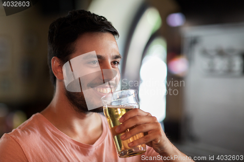 Image of happy man drinking beer at bar or pub