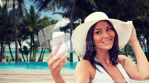 Image of young woman taking selfie with smartphone