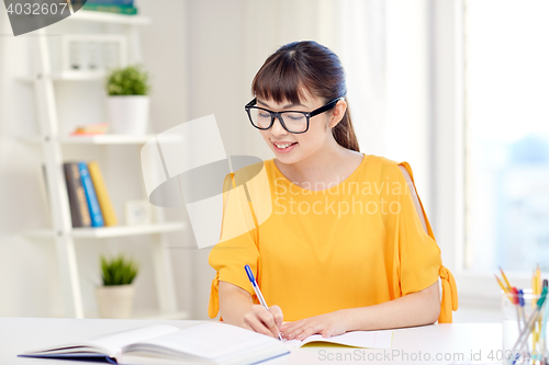 Image of happy asian young woman student learning at home