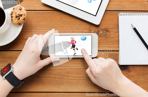 Image of close up of woman with fitness app on smartphone