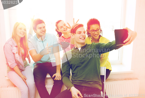 Image of smiling students making picture with tablet pc