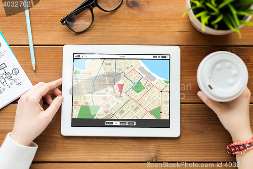 Image of close up of woman with tablet pc on wooden table