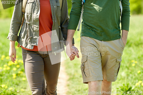 Image of close up of couple with backpacks holding hands