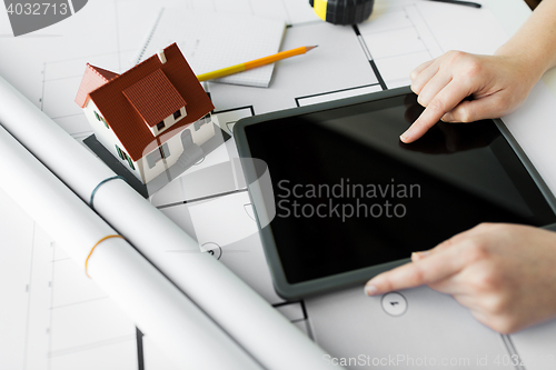 Image of close up of hand with blueprint and tablet pc