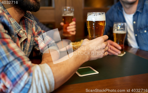 Image of happy male friends drinking beer at bar or pub