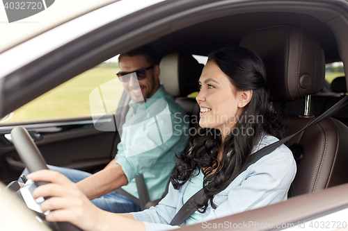 Image of happy man and woman driving in car