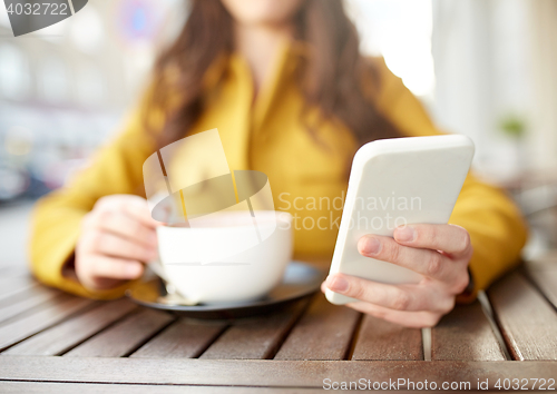 Image of close up of woman texting on smartphone at cafe