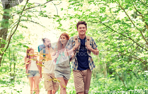 Image of group of smiling friends with backpacks hiking