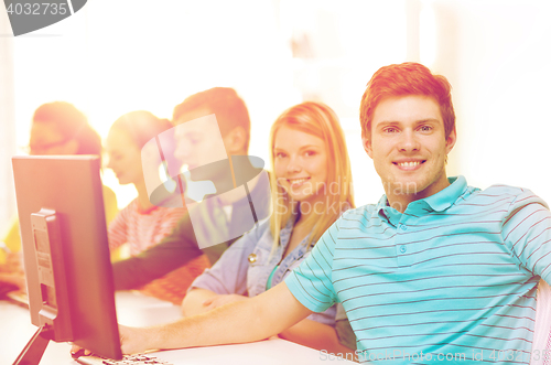 Image of male student with classmates in computer class