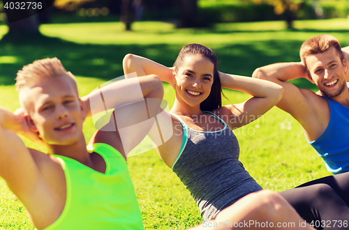 Image of group of friends or sportsmen exercising outdoors