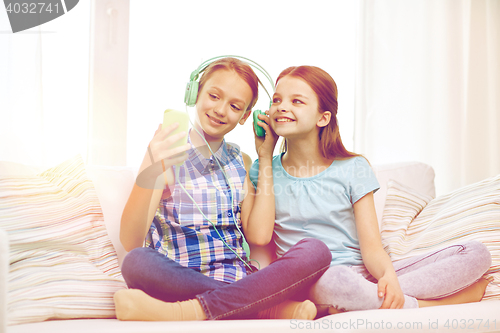 Image of happy girls with smartphone and headphones