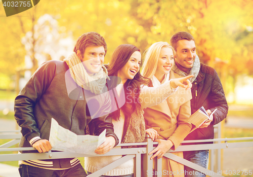 Image of couples with tourist map in autumn park