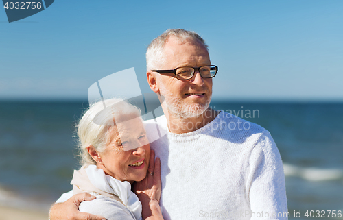 Image of happy senior couple hugging on summer beach