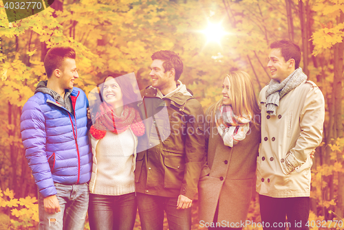 Image of group of smiling men and women in autumn park