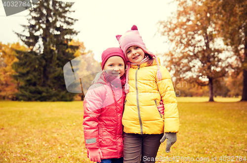 Image of two happy little girls hugging in autumn park