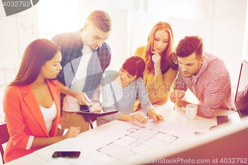 Image of creative team with blueprint working at office