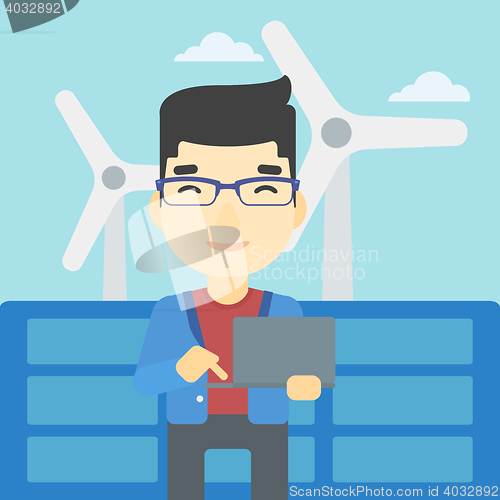 Image of Man checking solar panels and wind turbines.