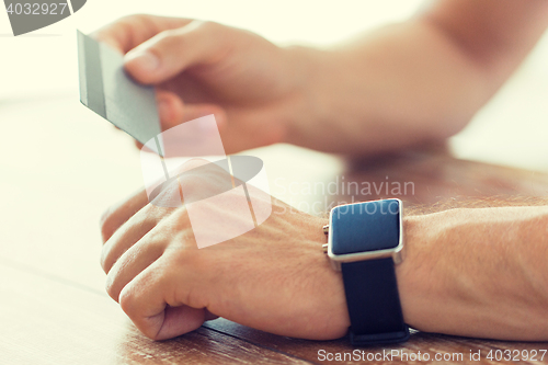 Image of close up of hands with smart watch and credit card